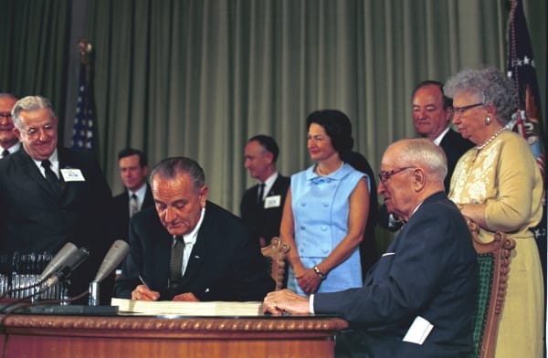 President Lyndon Johnson signs Medicare into law in 1965