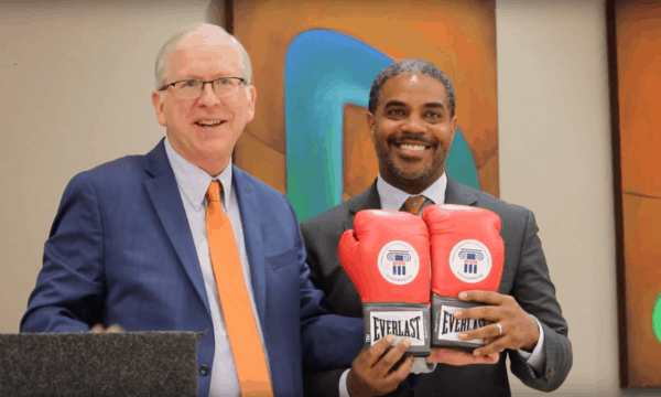 National Committee legislative director Dan Adcock presents Rep. Horsford with NCPSSM's signature boxing gloves
